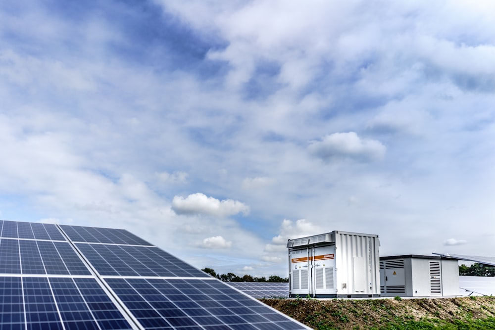 white and black solar panels under white clouds and blue sky during daytime