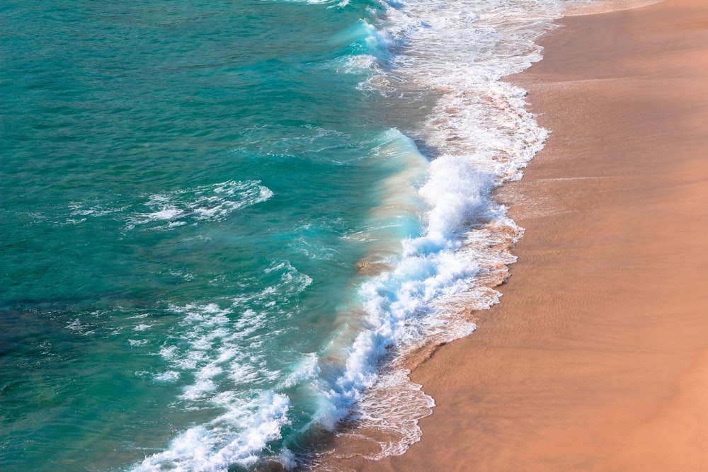 aerial view of ocean waves on shore during daytime