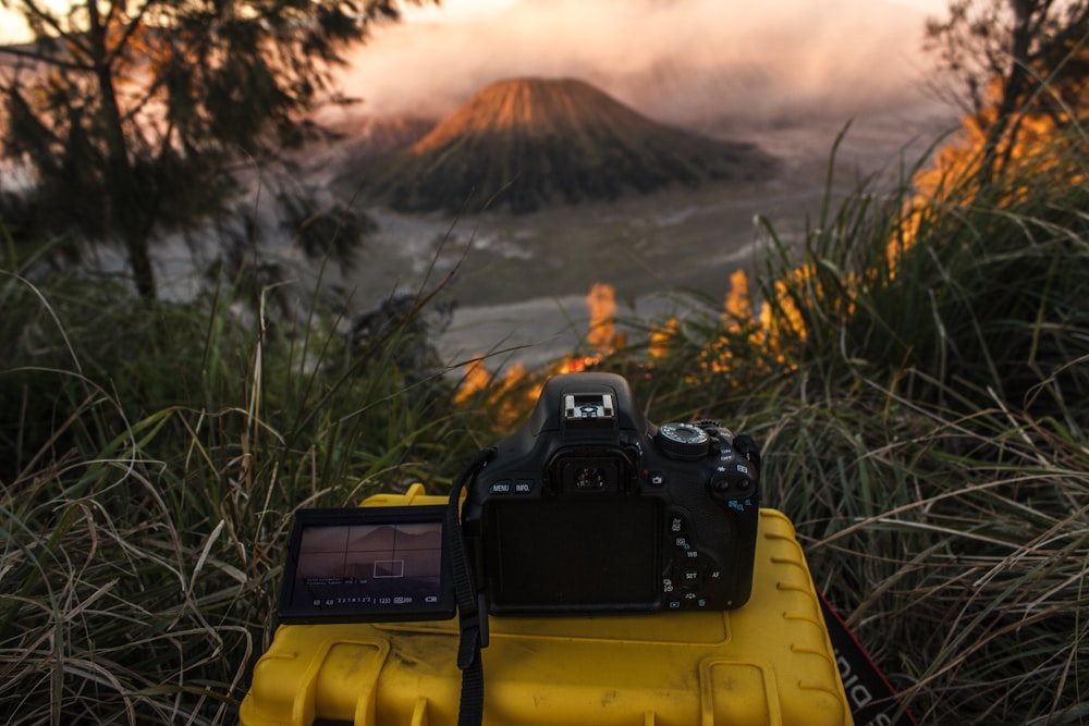 black nikon dslr camera on yellow plastic container