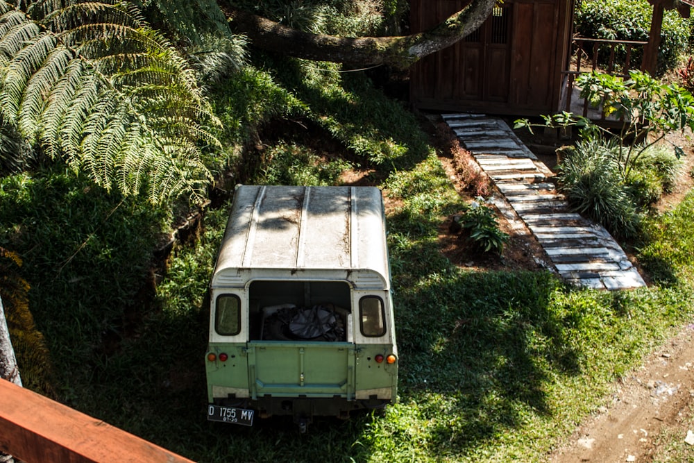 green and white van parked beside brown wooden fence