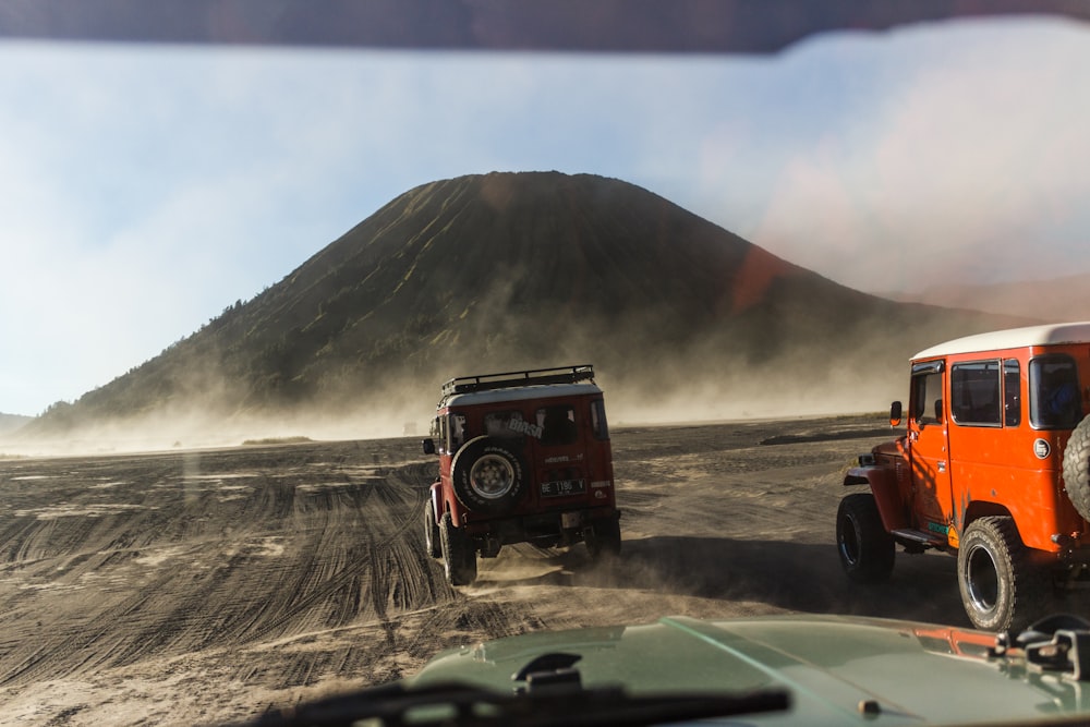 red and black jeep wrangler on dirt road during daytime