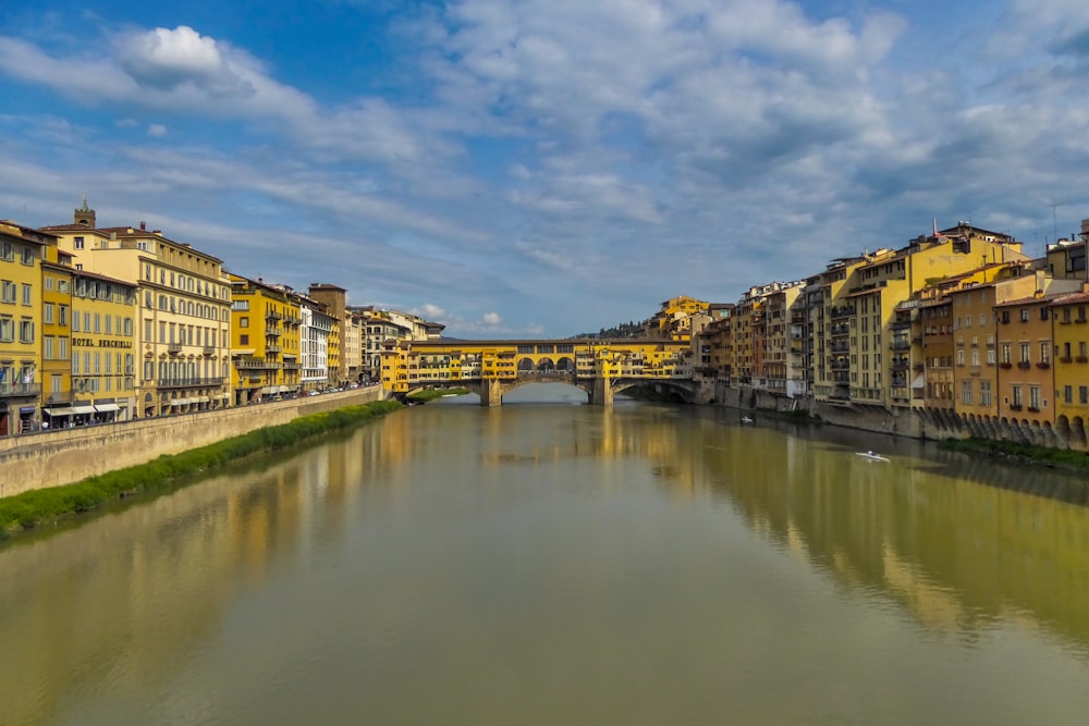 Braunes Betongebäude am Fluss unter blauem Himmel tagsüber