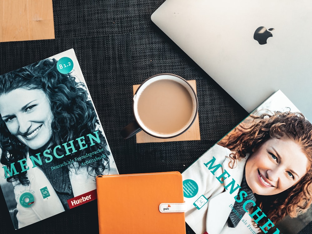 woman in black and white shirt beside silver macbook