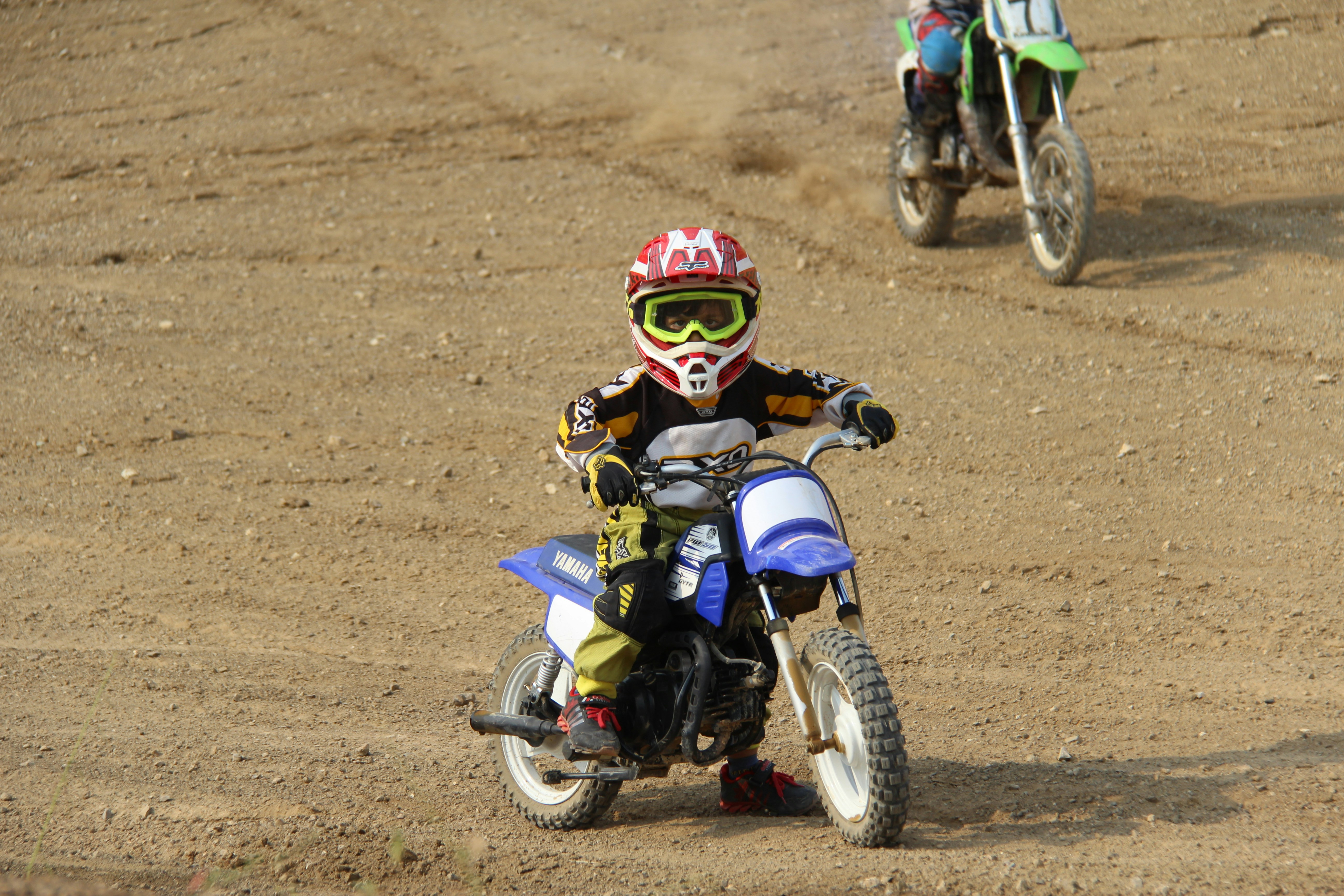 man in blue and red motorcycle suit riding blue and white motocross dirt bike