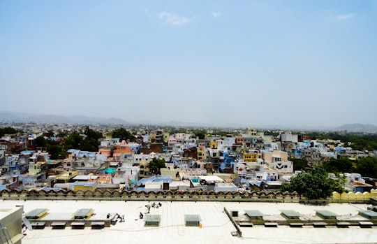 white concrete buildings under white sky during daytime in Chittorgarh India