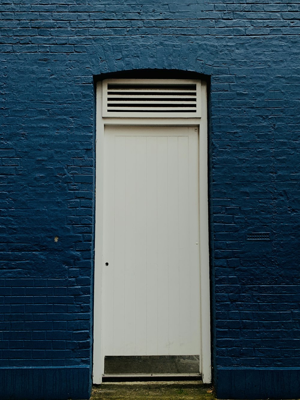 white wooden door with black metal window grill