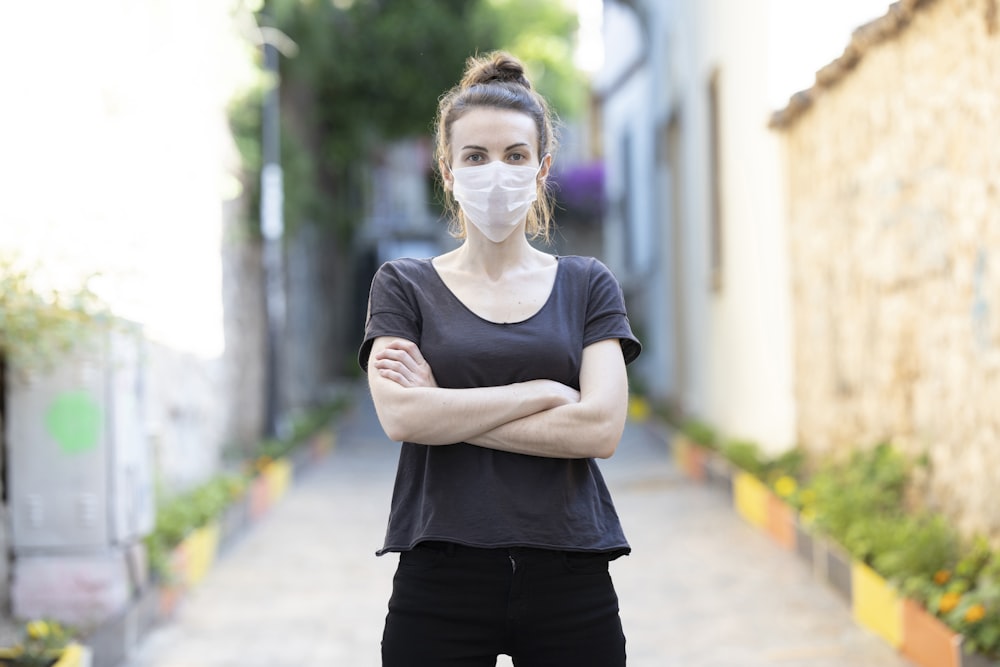 woman in black crew neck t-shirt and black pants wearing eyeglasses standing on pathway during