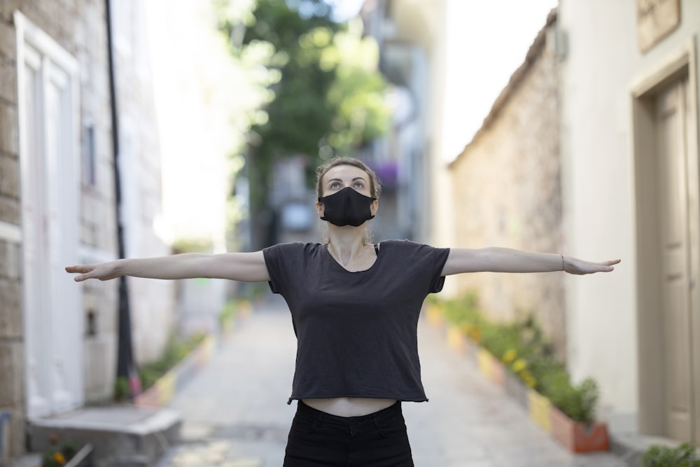 woman in black t-shirt and black shorts raising her hands