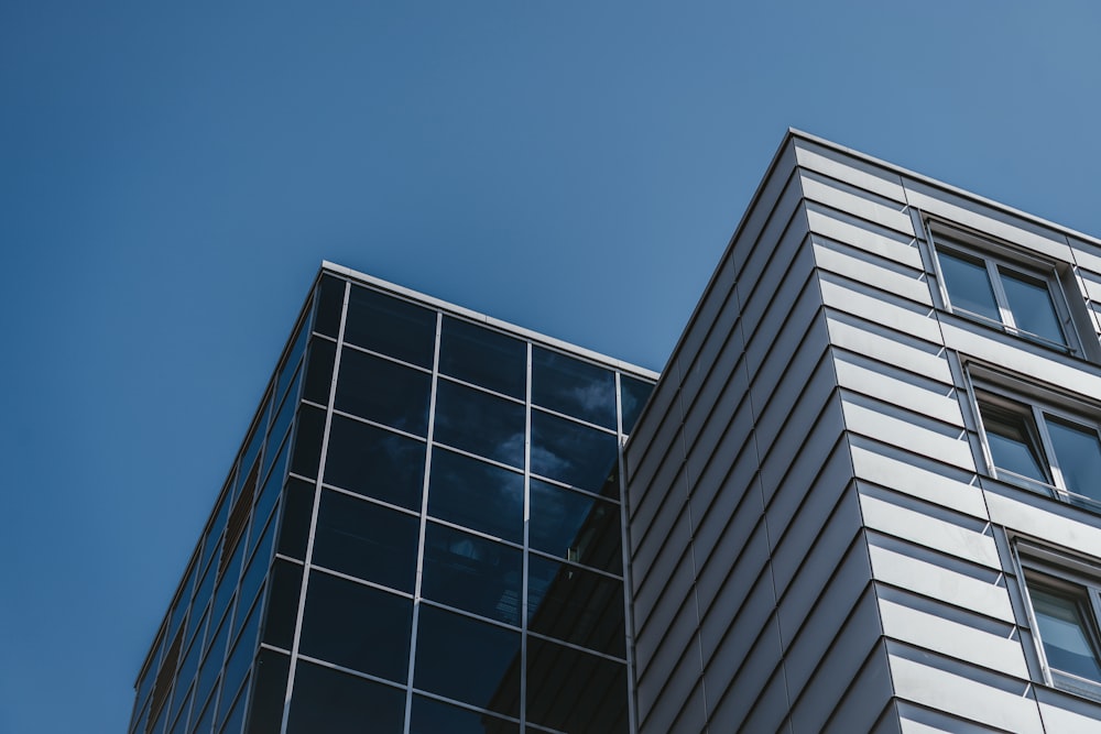 昼間の青空下のガラス張り高層ビルのローアングル撮影