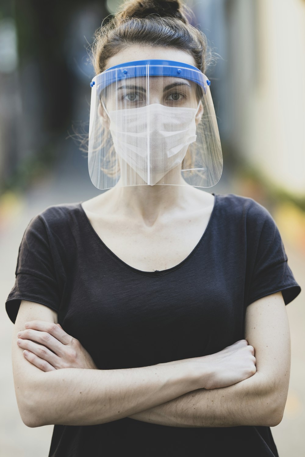 Mujer con camisa negra de cuello redondo con mascarilla blanca