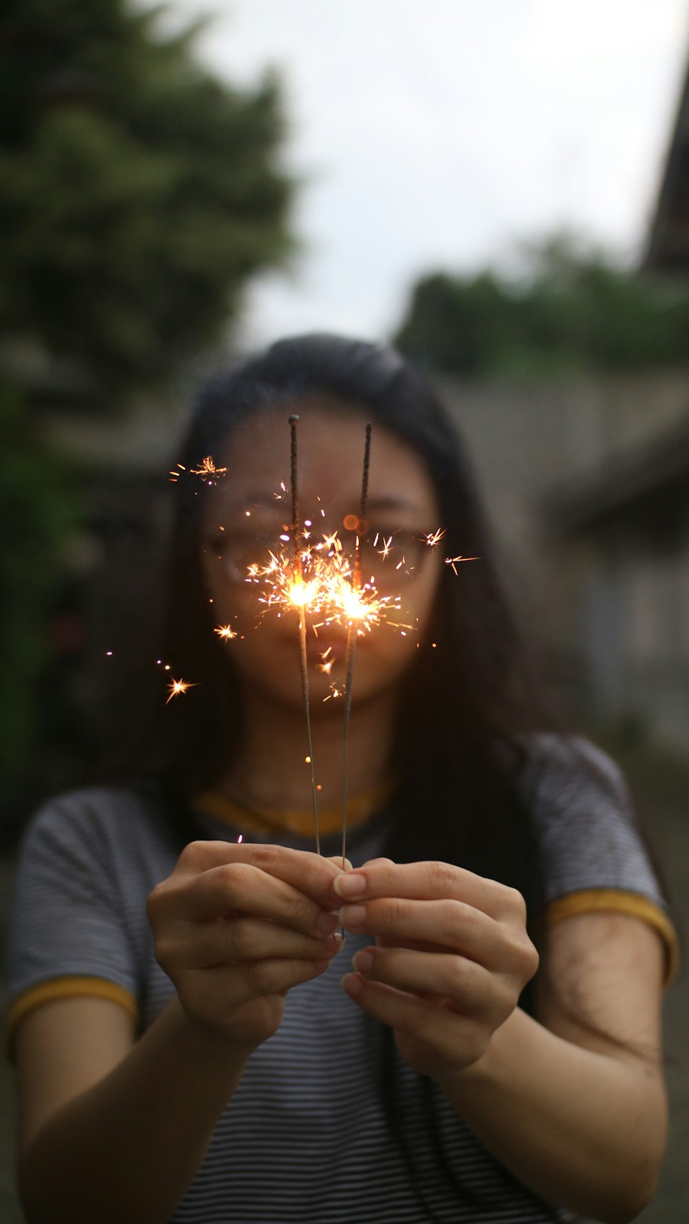 woman in gray sweater holding sparkler