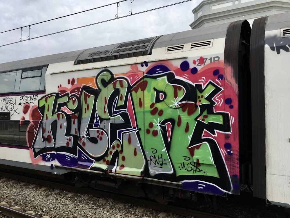 white purple and green graffiti art on train rail