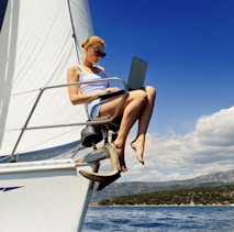 woman in white tank top sitting on white boat during daytime
