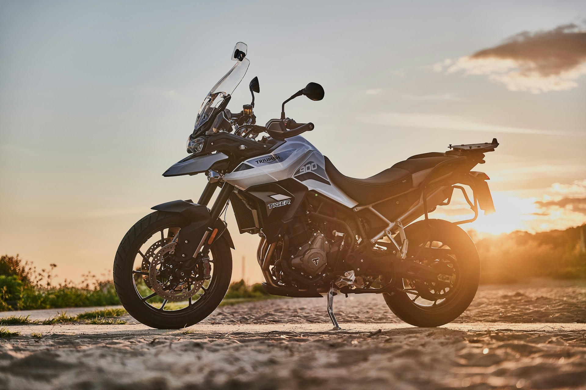 black and orange sports bike on brown sand during sunset