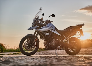 black and orange sports bike on brown sand during sunset