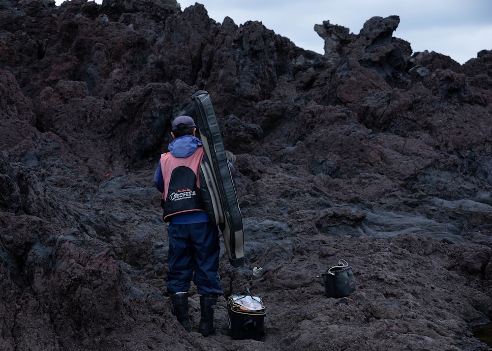 man in red and black jacket carrying black hiking backpack