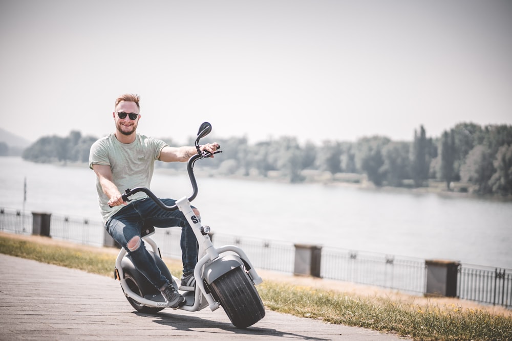 man in gray crew neck t-shirt riding black motorcycle during daytime