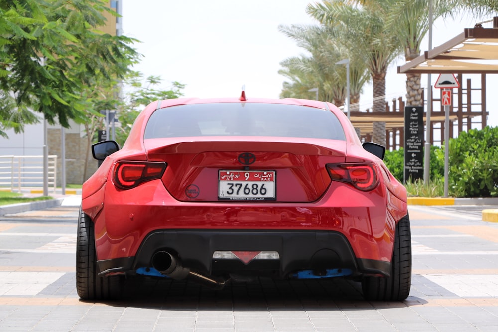 red bmw m 3 parked on sidewalk during daytime