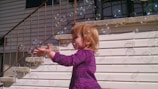 A joyful child playing with bubbles on a bright summer day.