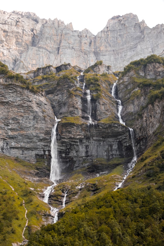 waterfalls on green grass covered mountain during daytime in Haute-Savoie France