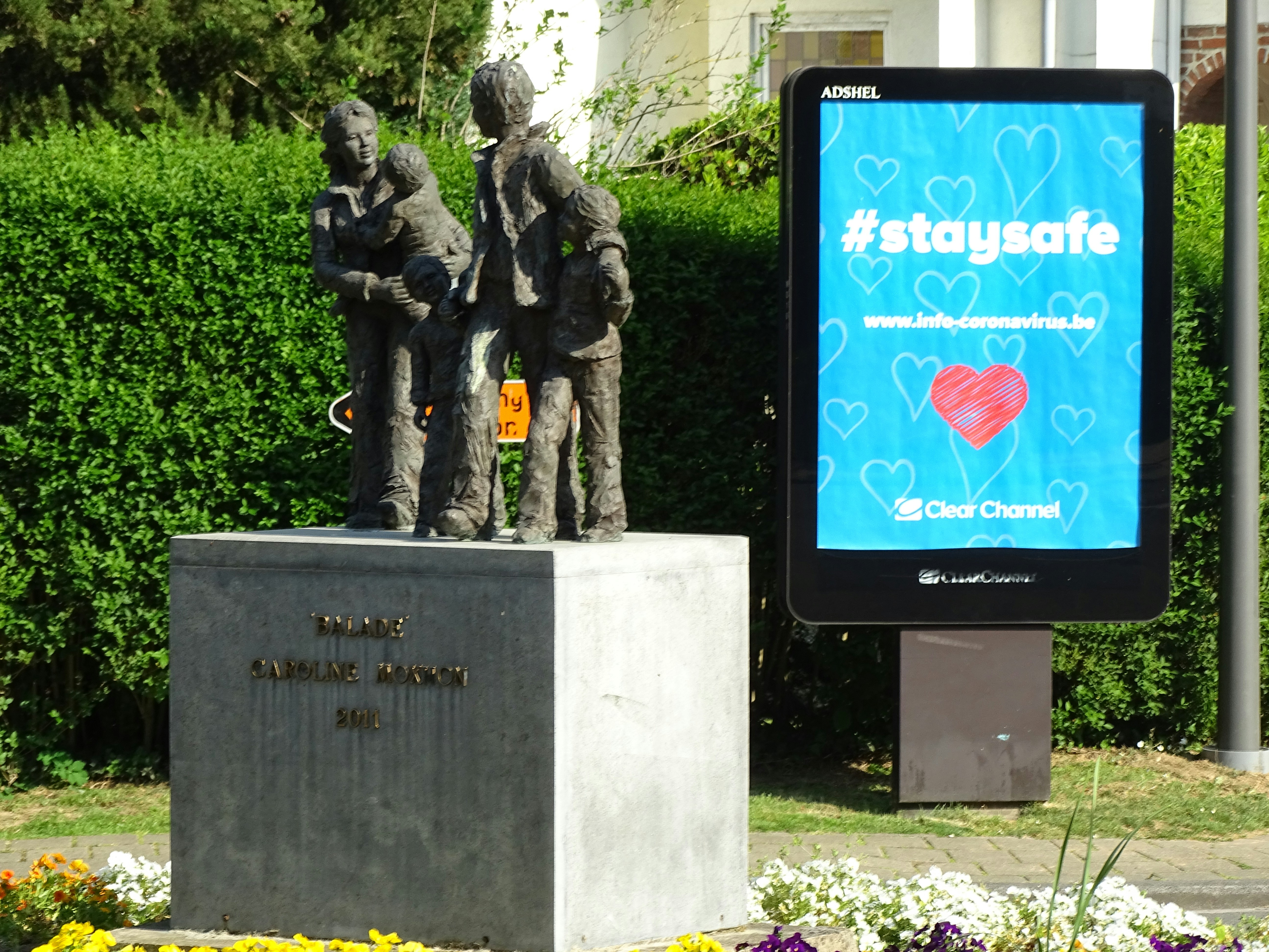 a statue of a group of people in front of a sign