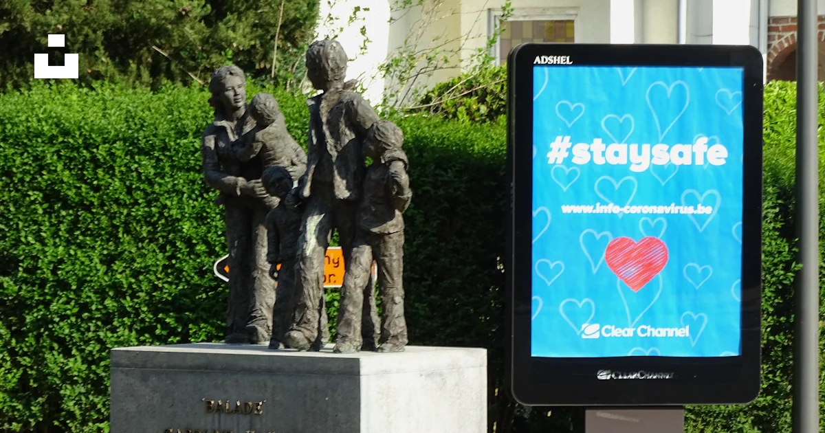 Collection Infront Sign A statue of a group of people in front of a sign photo – Free Person ...
