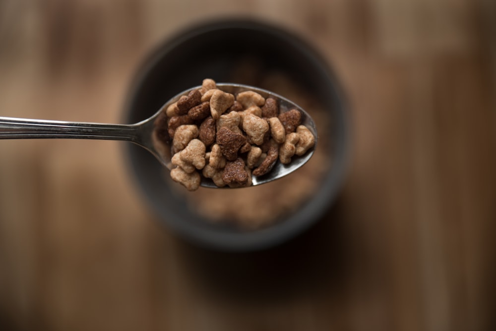 brown peanuts in black ceramic bowl