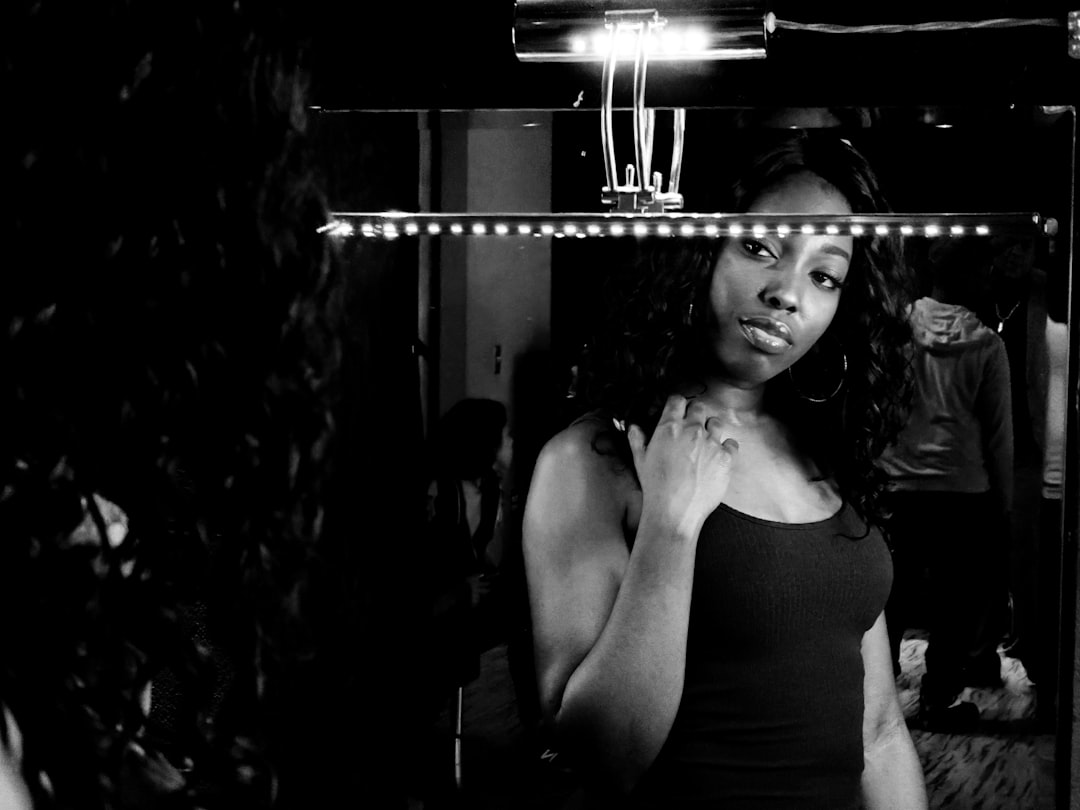 woman in black tank top, A woman looks at herself in the mirror as she prepares to star in a music video.