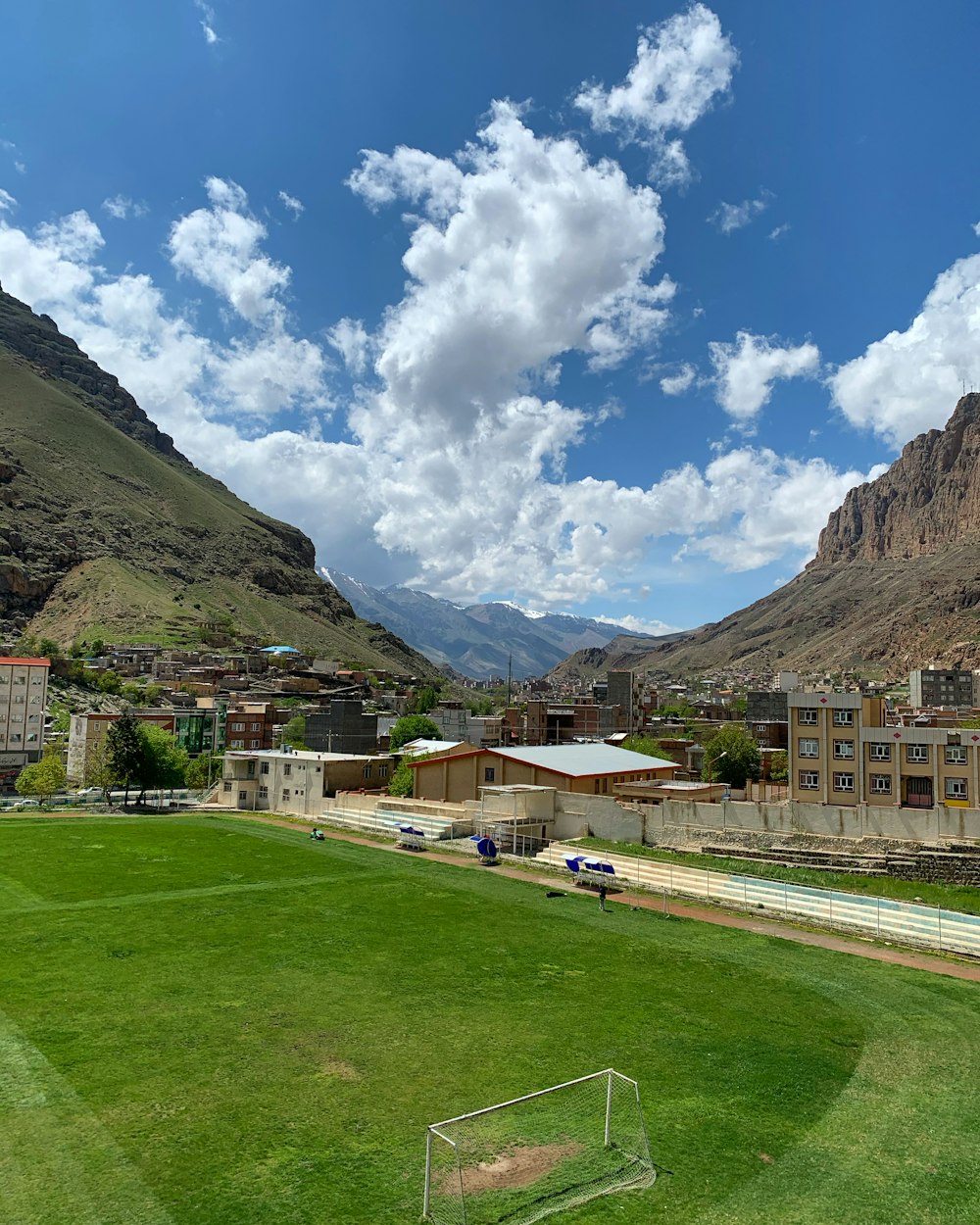 houses near green mountain under blue sky during daytime