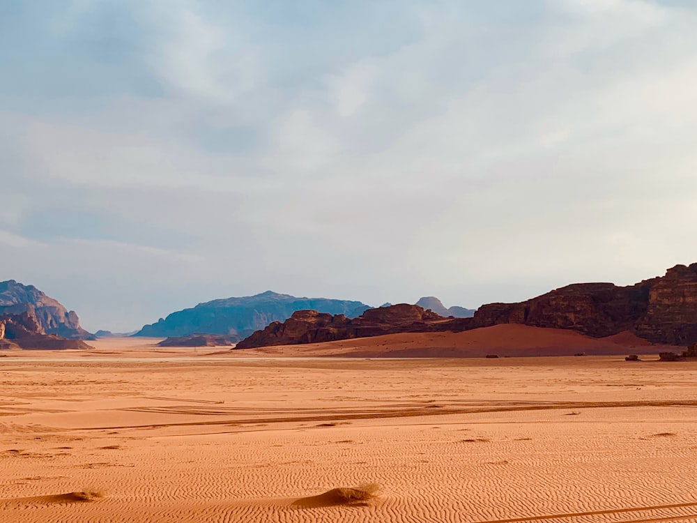 brown sand under white clouds during daytime