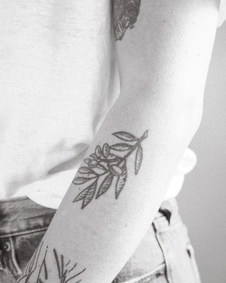 A black-and-white olive branch tattoo, standing in for the teardrop flame silhouette of flash design №004