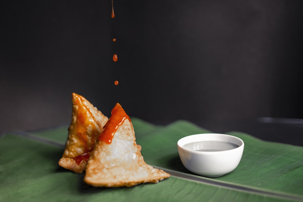 white ceramic bowl beside brown bread on green ceramic plate