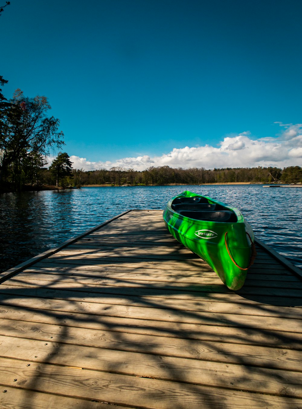 Kayak verde en muelle de madera marrón durante el día