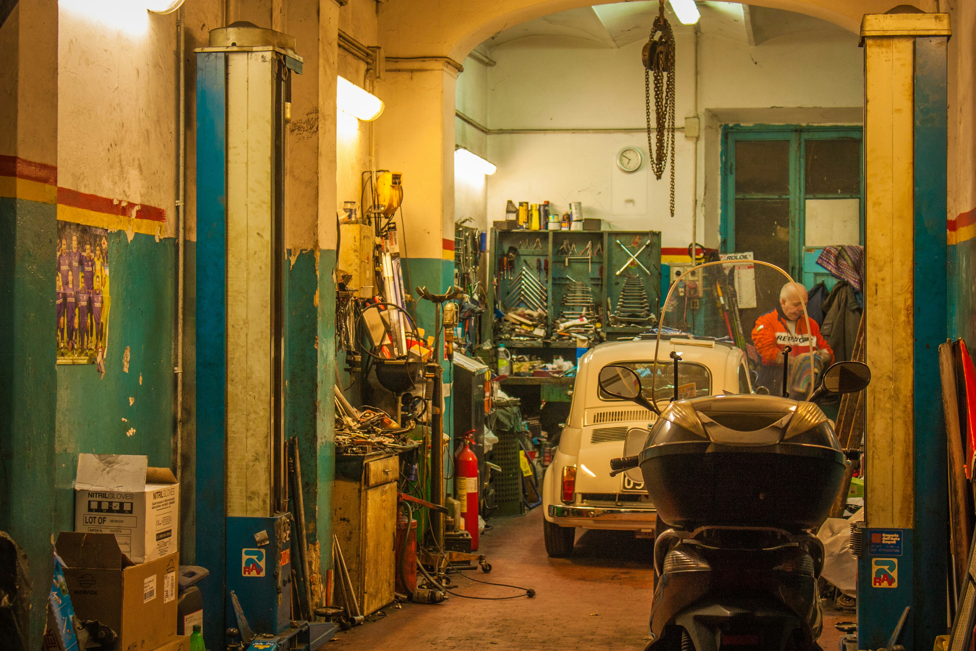 white and black auto rickshaw parked beside blue and green wall