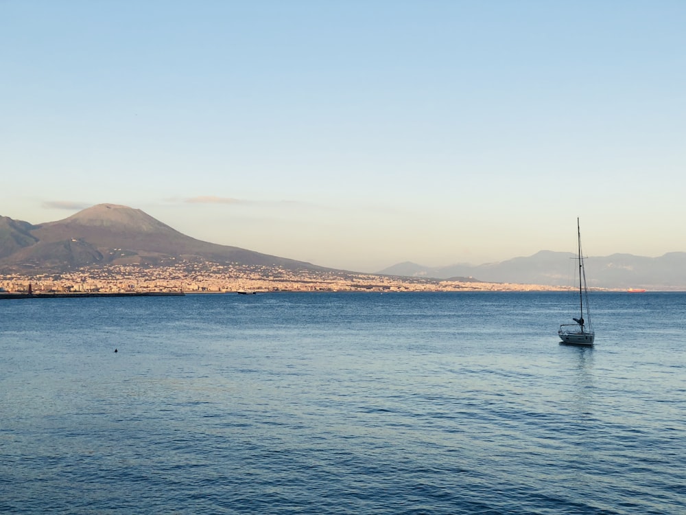 boat on sea near island during daytime