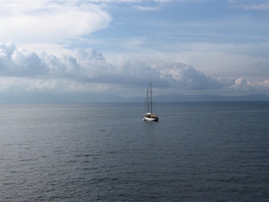 white sailboat on sea under white clouds and blue sky during daytime in Naples Italy
