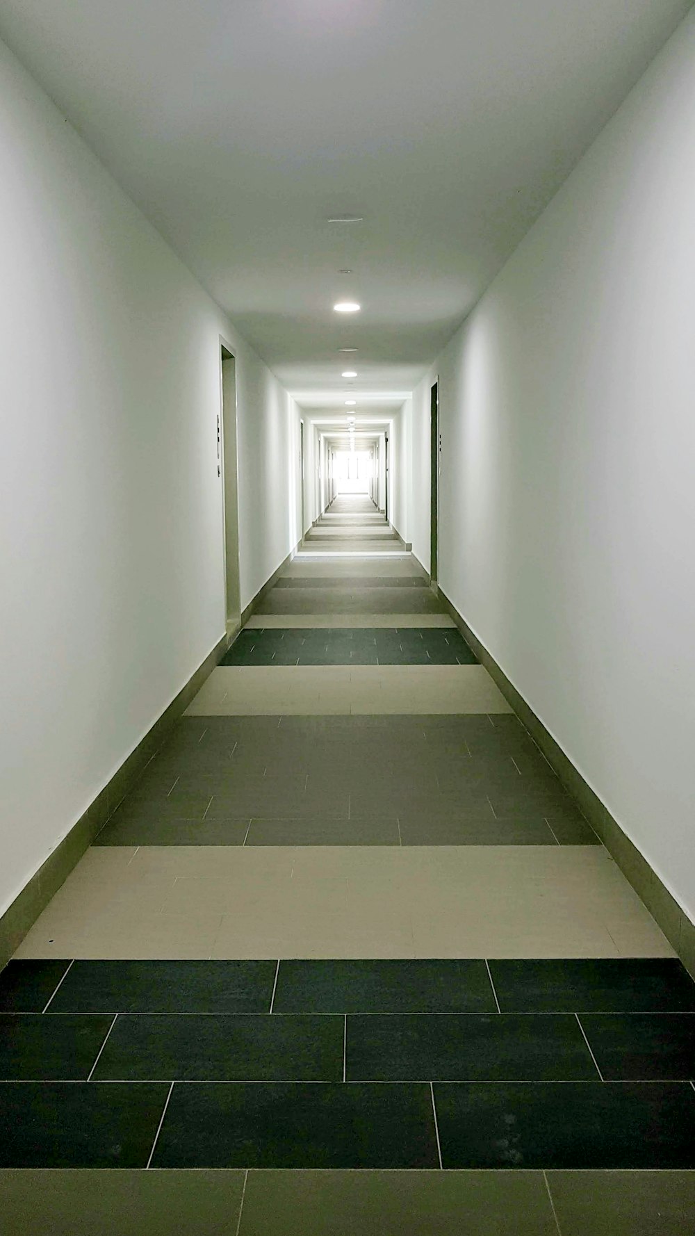 白い壁に白いコンクリートの廊下