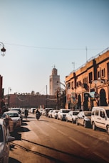 cars parked on street near brown concrete building during daytime