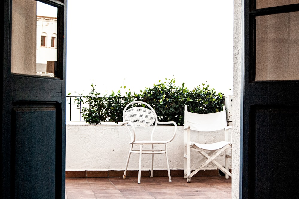 white metal armchair beside white wall