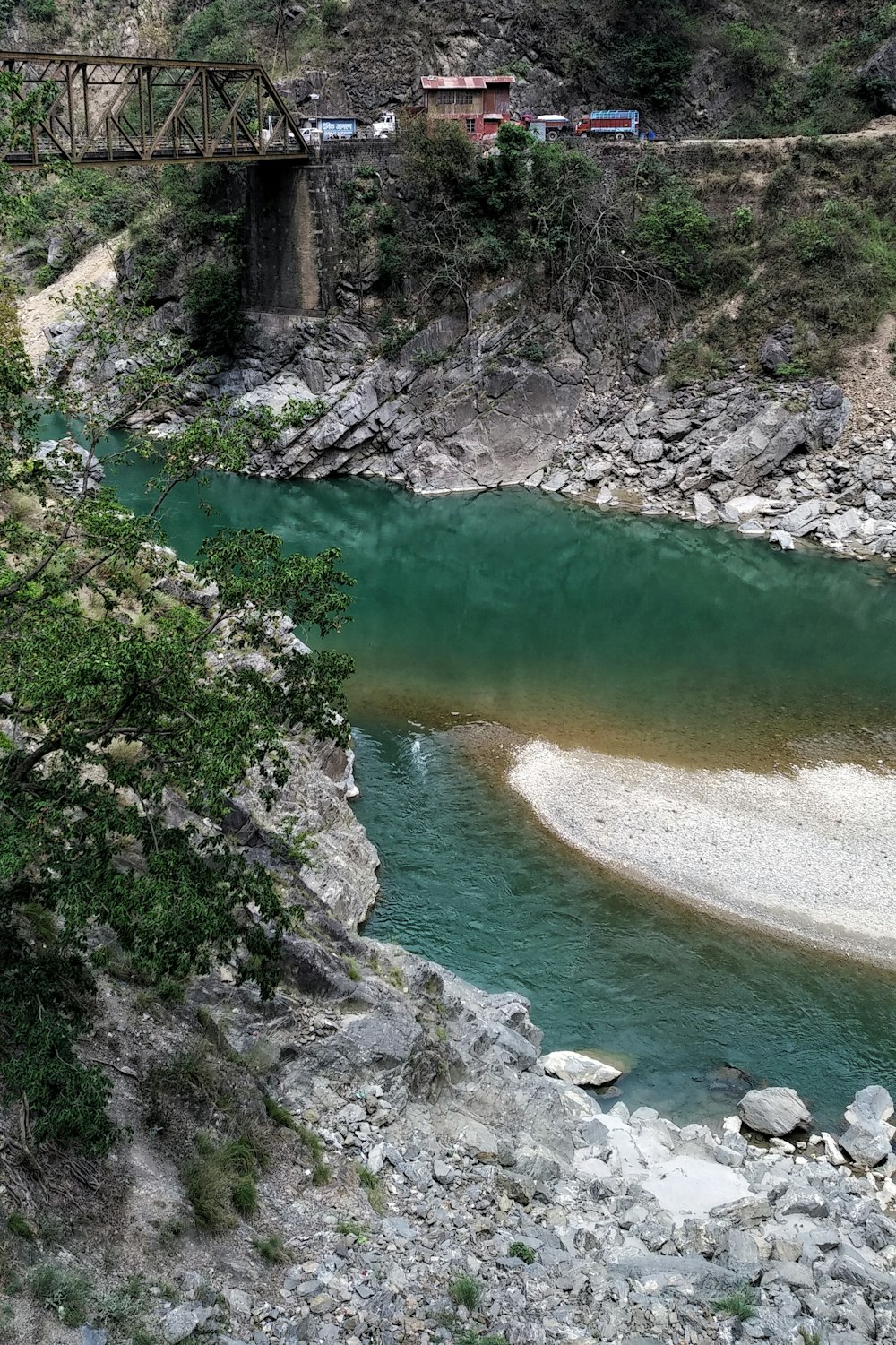 낮에는 회색 록키 산 사이의 녹색 강