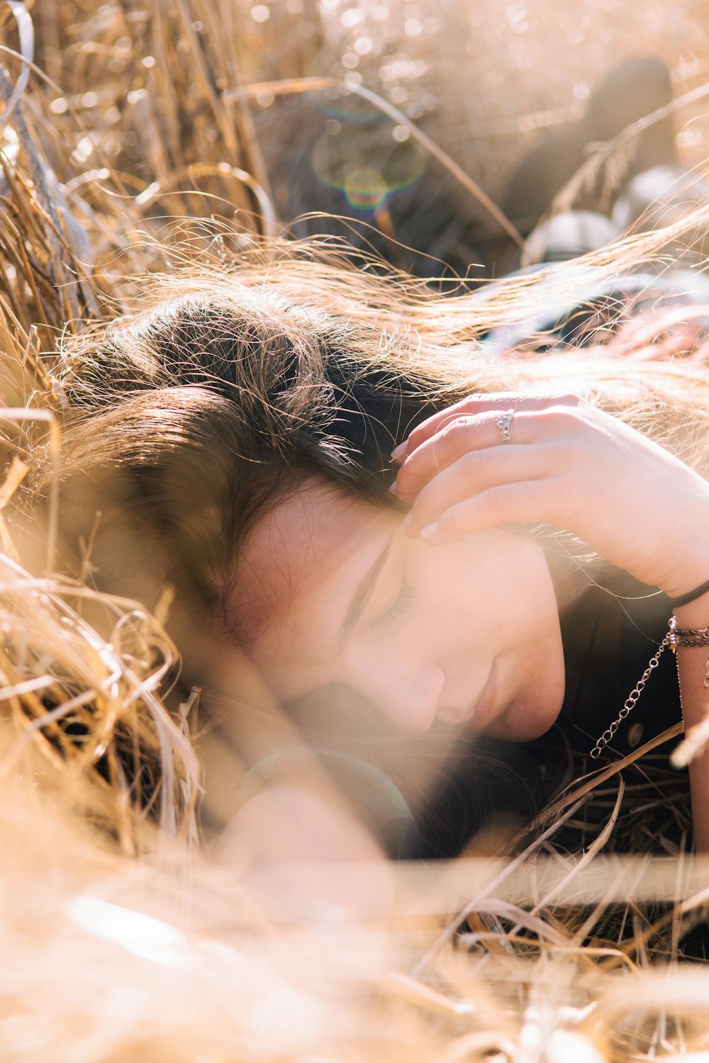 woman in brown long sleeve shirt lying on brown grass during daytime