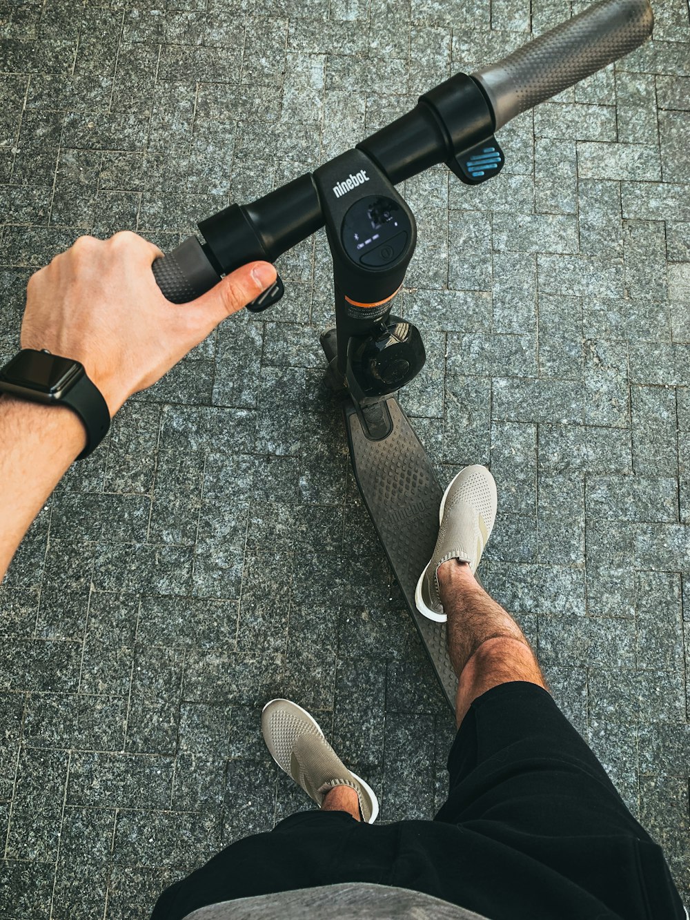 Person in schwarzen Shorts und braunen Slipper