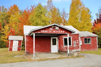 white and red wooden house near trees during daytime