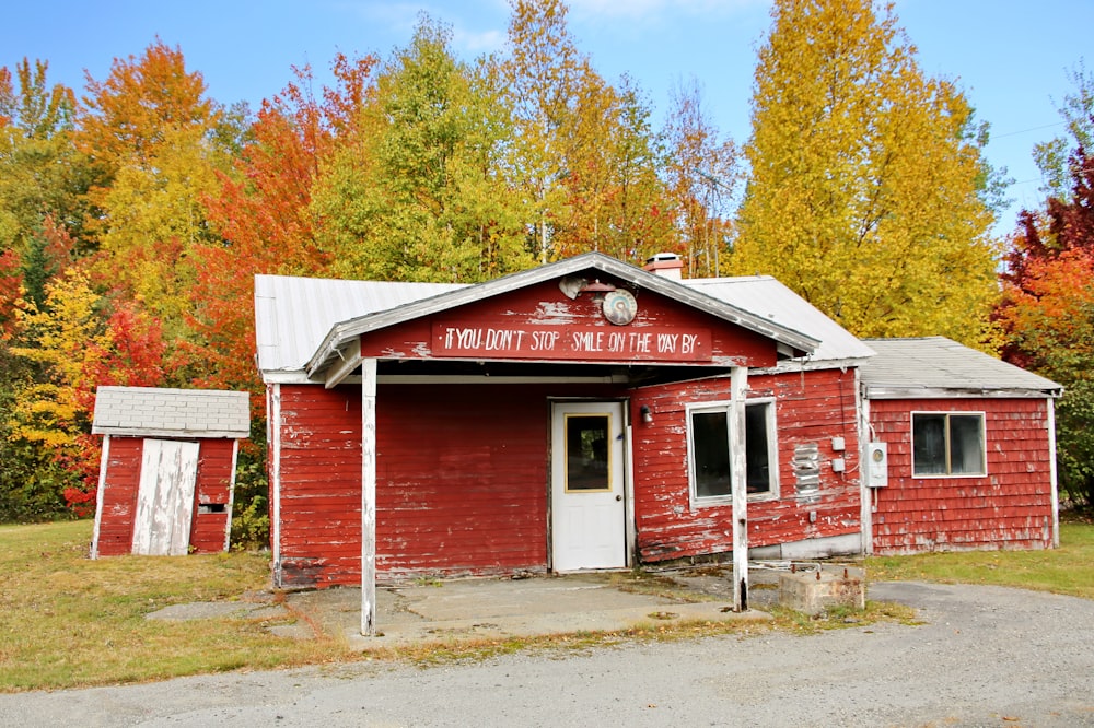 Maison en bois blanc et rouge près des arbres pendant la journée