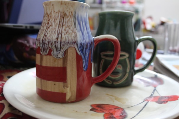 Two mugs with complementary designs placed on a cozy table.