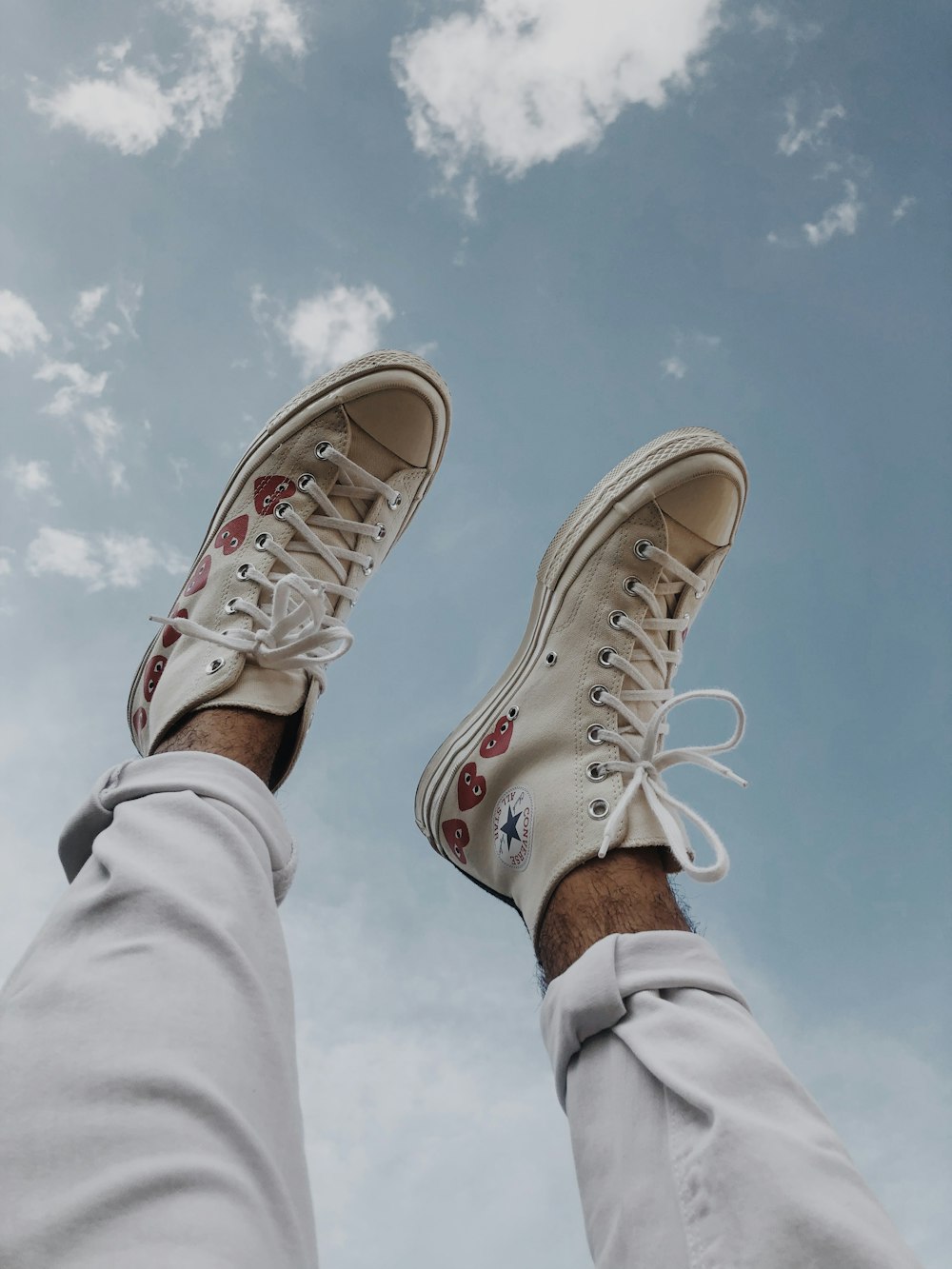 Persona che indossa scarpe da ginnastica alte Converse All Star marroni