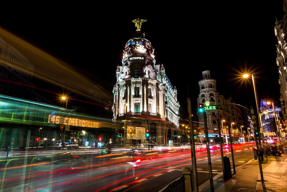 time lapse photography of cars on road near building during night time