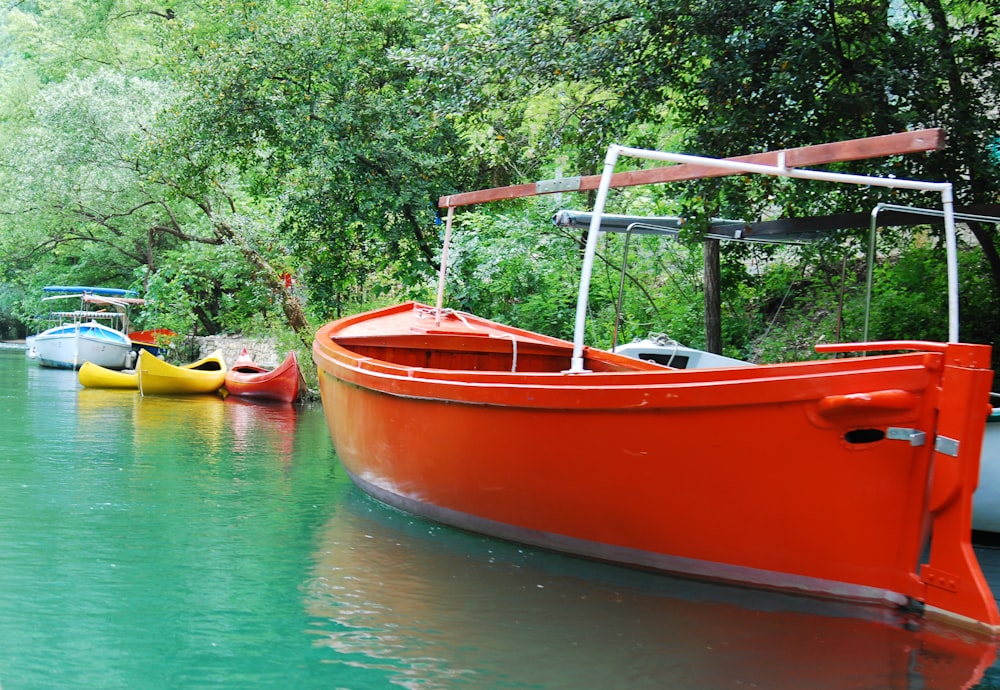 red and yellow boat on body of water during daytime