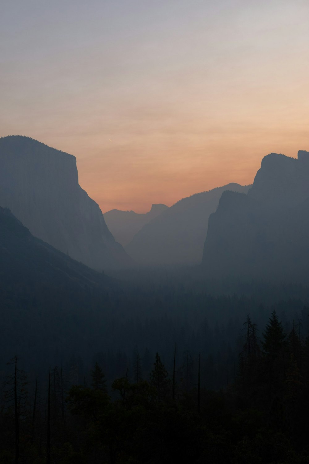 silhouette of trees and mountains during sunset