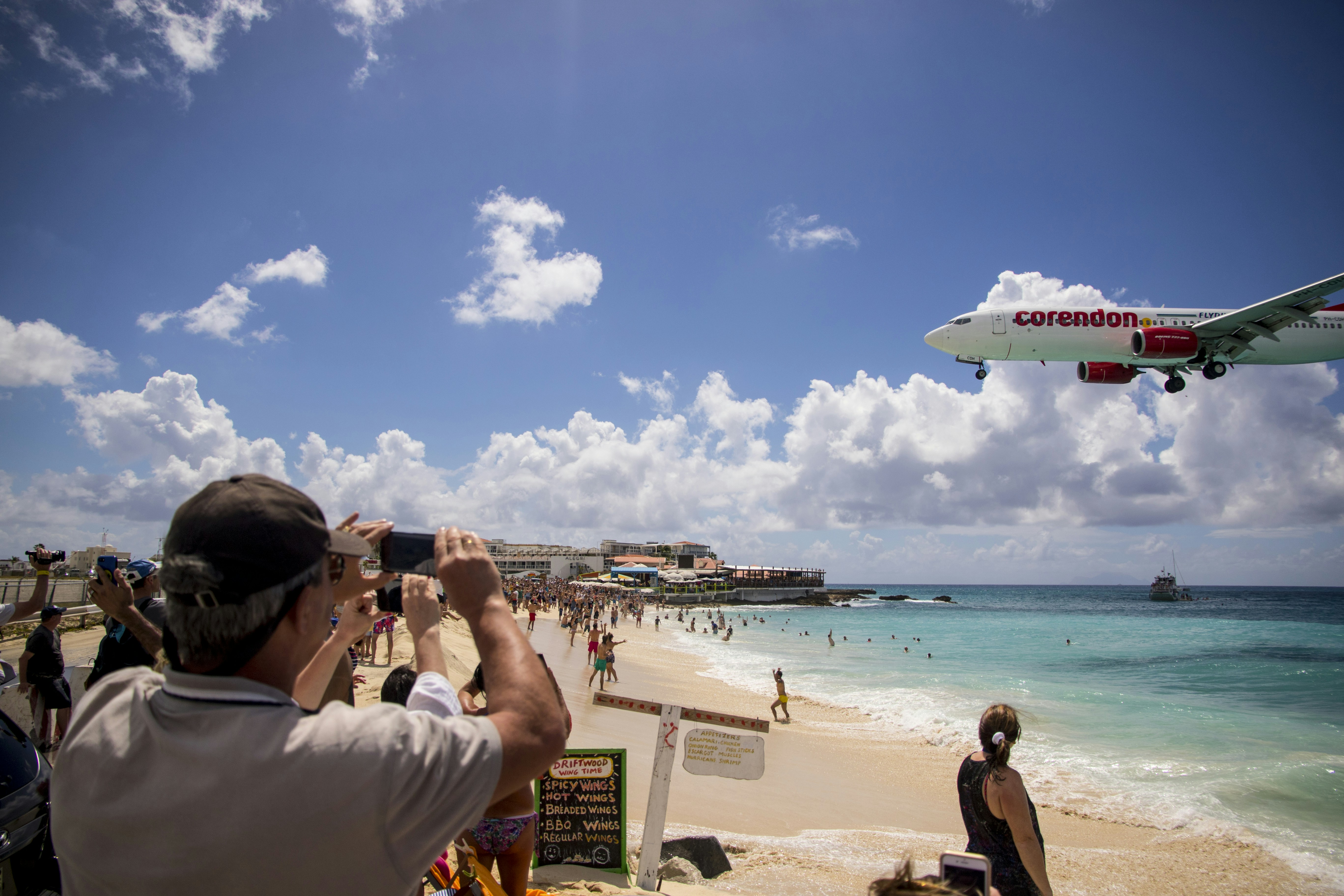 people on beach during daytime, Plane over Beach - St. Maarten